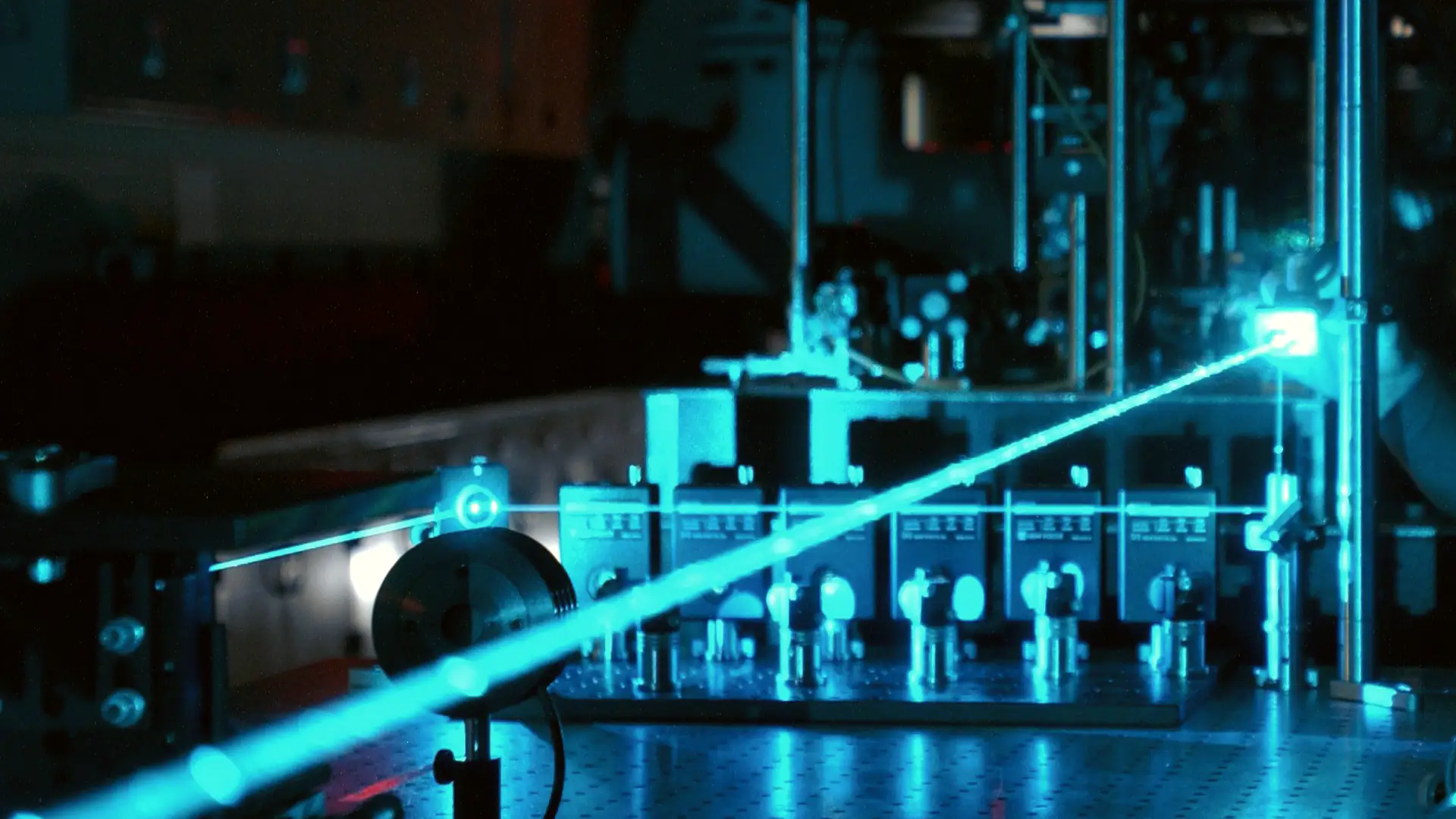 Optics table with lenses and mirrors in a laser research lab